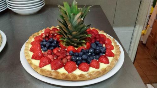 a fruit pizza on a plate with a pineapple and strawberries at Villa Grazia in Viareggio