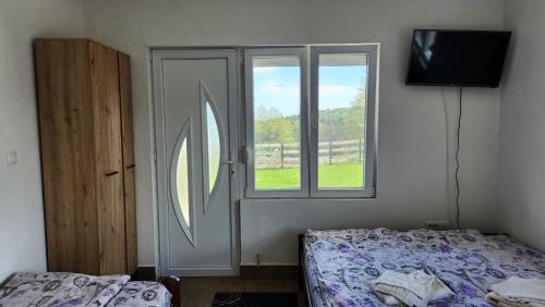 a bedroom with a door and a bed and a window at Kuća sa lepim pogledom - porodica Čolović in Rudno