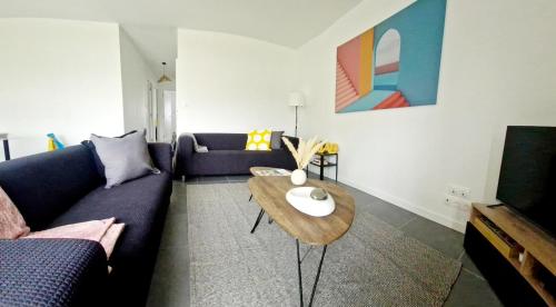 a living room with a couch and a table at Maison avec jardin en plein coeur de la Gacilly in La Gacilly