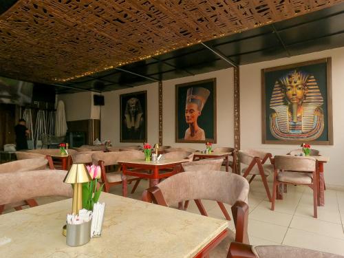 a restaurant with tables and chairs and portraits on the walls at Giza Pyramids View Inn in Cairo