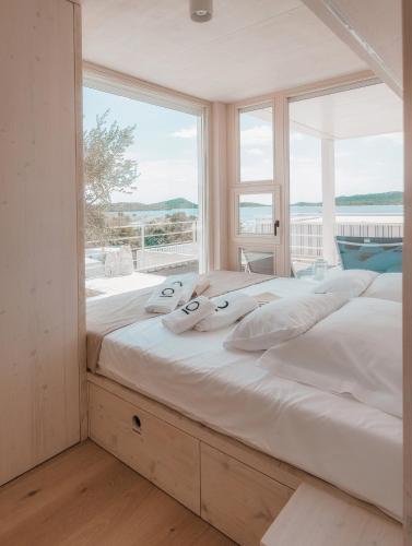 a large bed in a room with a large window at Vila Amara - Resort Vita in Drage