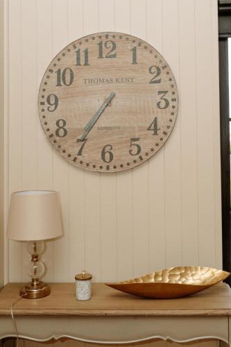 a clock hanging on a wall above a table at Fisherman's Lodge at Angliham Estate in Kilroghter