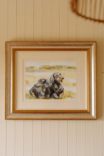 a painting of two dogs on a wall at Fisherman's Lodge at Angliham Estate in Kilroghter