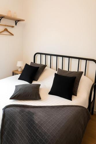 - une chambre avec un grand lit et des oreillers noirs dans l'établissement Escale Élégante Nancy, à Nancy
