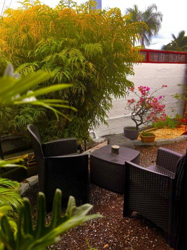 a patio with tables and chairs and plants at Studio Mohui RBNB in Punaauia