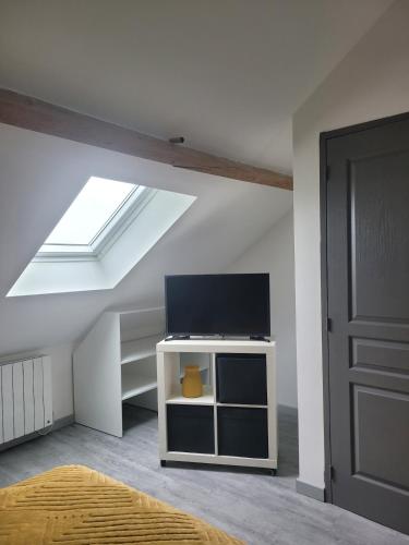 Cette chambre mansardée dispose d'une télévision à écran plat. dans l'établissement Maison calme et moderne, à Engenville