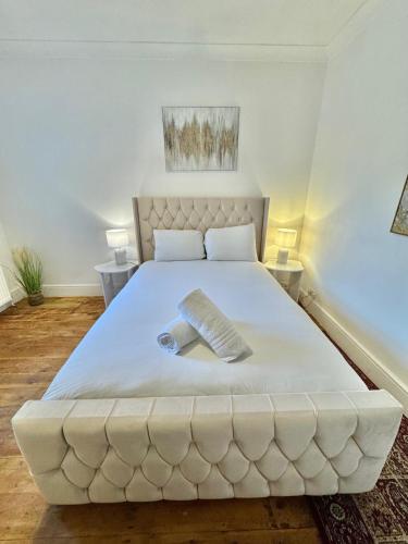 a large white bed in a room with two tables at Capstone Escape in Bournemouth