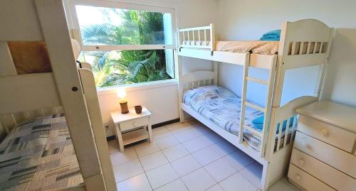 Una pequeña habitación con dos literas y una ventana. en Angra Praia do Café, en Angra dos Reis