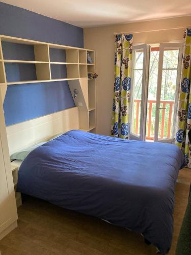une chambre avec un lit bleu et une fenêtre dans l'établissement Maison à Lacanau Océan avec piscine, proche océan, lac, golf, à Lacanau