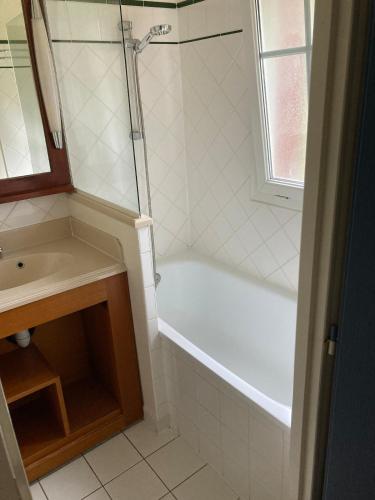 une salle de bain avec une baignoire blanche et un lavabo dans l'établissement Maison à Lacanau Océan avec piscine, proche océan, lac, golf, à Lacanau