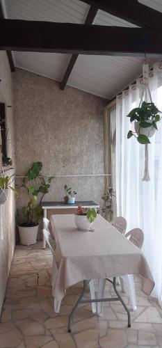 une salle à manger avec une table et des chaises et une fenêtre dans l'établissement ARTS & Passion, à Mirambeau