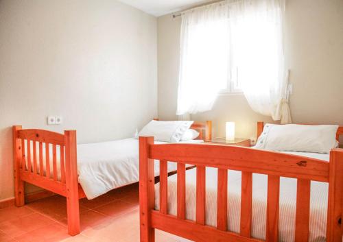 a bedroom with two beds and a window at Casa Lanjaron B&B in San Miguel de Salinas