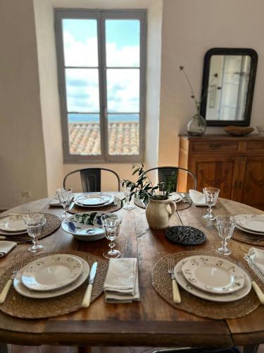 a wooden table with plates and utensils on it at Village House With Valley View In Tourrettes in Tourrettes