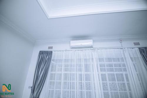 a window with a curtain in a room at N3 Luxury Suite in Mzuzu