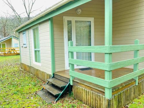 - une terrasse couverte à l'avant d'une maison avec une porte dans l'établissement Chalet cosy au cœur de la nature, à Lissac-sur-Couze