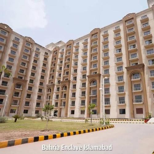 a large building with a courtyard in front of it at Studio Murree facing apartment In Bahria Enclave in Islamabad