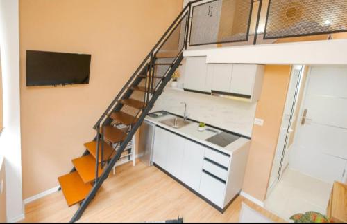a loft kitchen with a staircase and a sink at Alvin House in Shkodër