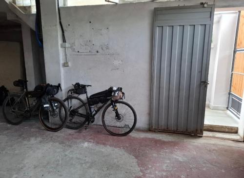 two bikes parked next to a wall with a door at Alvin House in Shkodër
