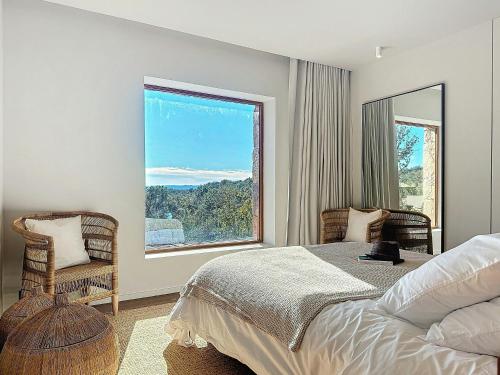 une chambre avec un lit et une grande fenêtre dans l'établissement Authentic Villa In The Corsican Maquis, à Lecci