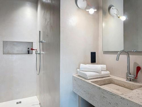 La salle de bains est pourvue d'un lavabo, d'une douche et de serviettes. dans l'établissement Authentic Villa In The Corsican Maquis, à Lecci
