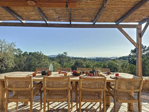 - une table et des chaises en bois sur une terrasse avec vue dans l'établissement Authentic Villa In The Corsican Maquis, à Lecci