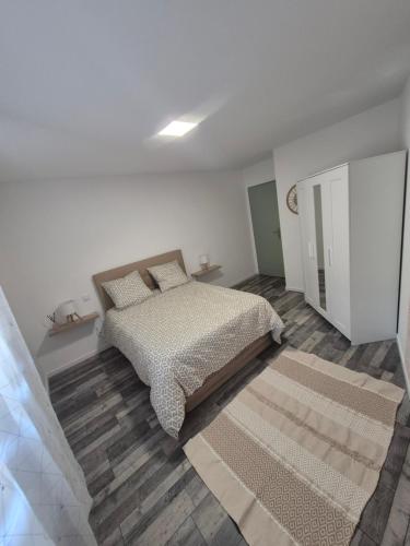 une chambre avec un lit dans une pièce blanche dans l'établissement Havre de paix, à Calvisson