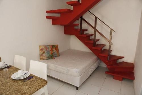 a room with a bed and a red staircase at Tamandaré Residence Beach 3 in Tamandaré