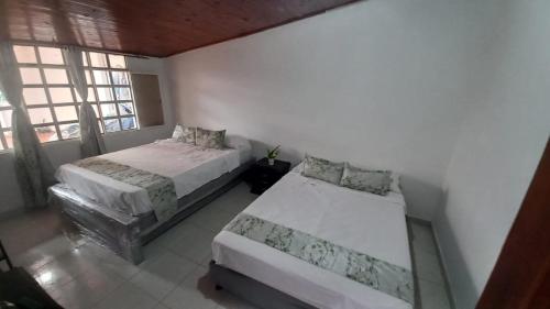 a bedroom with two beds and a window at Casa Villetana in Villeta