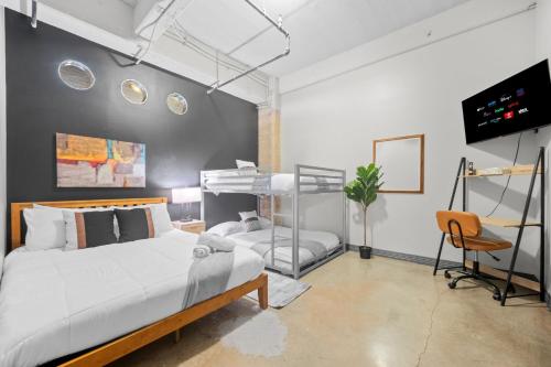 a bedroom with a bed and a desk and a tv at Stunning Downtown Apartment with Pool, Laundry, Parking in Dallas