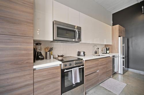 a kitchen with a stove and a microwave at Stunning Downtown Apartment with Pool, Laundry, Parking in Dallas