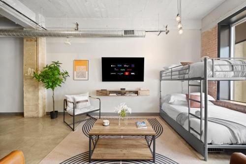 a loft bedroom with bunk beds and a tv at Stunning Downtown Apartment with Pool, Laundry, Parking in Dallas