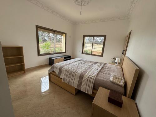 une chambre avec un grand lit et deux fenêtres dans l'établissement Zs Farm Kamouni - WIFI Fibre - Jacuzzi on request, à Sidi Allal el Bahraoui