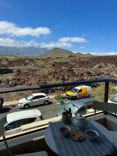 a table on a balcony with a view of a parking lot at Malpais in Puertito de Güímar
