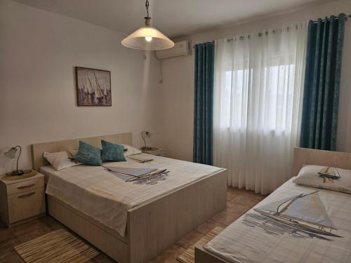 a bedroom with two beds and a window at B & M Apartments in Kotor