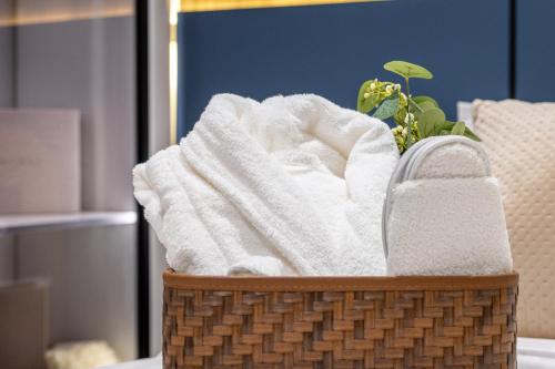 a basket filled with towels and a plant at Delmar Luxury 3BR Apartment 4 in Jeddah