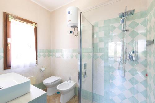 a bathroom with a shower and a toilet and a sink at Giaco's Rooms in Villasimius