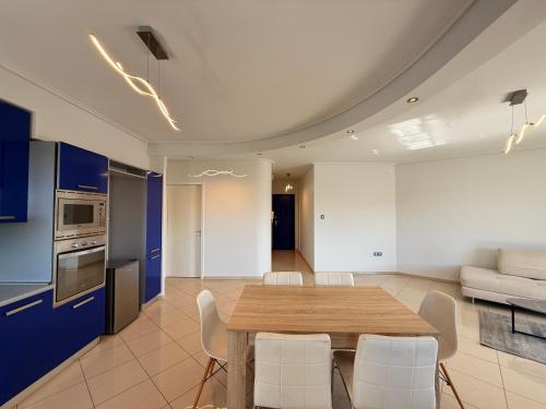 a kitchen and dining room with a wooden table and chairs at Sunny Home Private Jacuzzi Hydromassage, Fireplace, Acropolis & Lycabettus View, Underground Parking, 300m Metro Peristeri in Athens