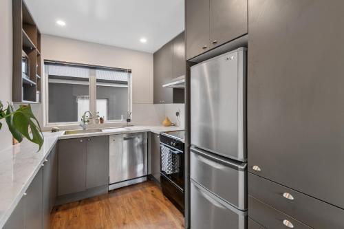 a kitchen with a stainless steel refrigerator at Central City Comfort and Style in Christchurch