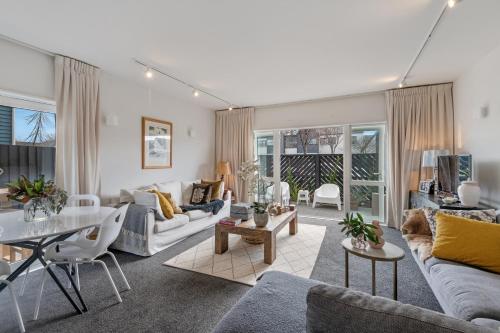a living room with a couch and a table at Central City Comfort and Style in Christchurch