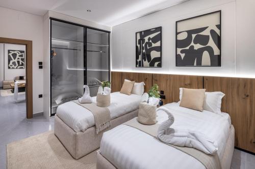 a bedroom with two beds with white sheets at Delmar Luxury 3BR Apartment 4 in Jeddah