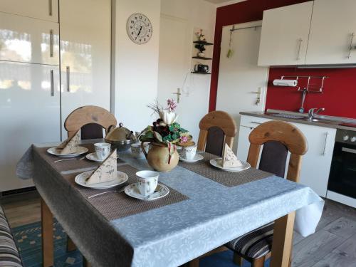 a table with cups and saucers on it in a kitchen at Ferienwohnung Irene in Strackholt in Großefehn 