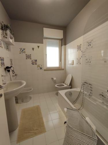 a bathroom with a toilet and a tub and a sink at Nice apartments lake view & free parking in Pastrengo