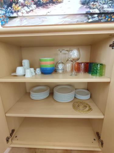 a shelf with plates and cups and dishes on it at Nice apartments lake view & free parking in Pastrengo