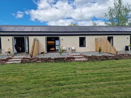 a white house with a patio and a yard at The Stables by Blake View Holidays, comprising The Nest, The Drey, The Burrow and the Den, 3 miles from Ennerdale in Rowrah