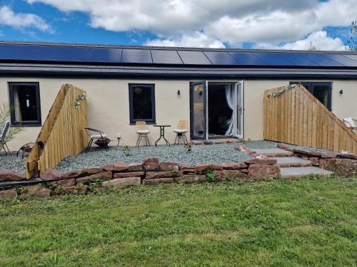 a house with a stone wall in front of it at The Stables by Blake View Holidays, comprising The Nest, The Drey, The Burrow and the Den, 3 miles from Ennerdale in Rowrah