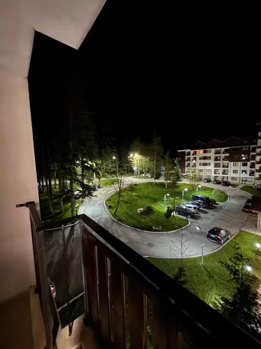 a balcony with a view of a parking lot at night at Borovets Gardens MVS Apart D42 in Borovets
