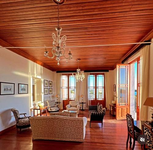 a living room with a wooden ceiling and a chandelier at Casa Crespo Hotel Boutique in Patagones