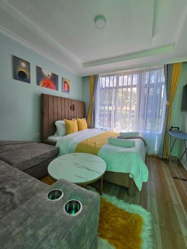 a hotel room with two beds and a couch at Neim Homes in Meru