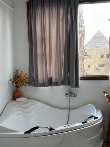 a bath tub in a bathroom with a window at Luxury Panorama pyramids & jacuzzi in Cairo