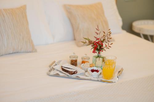 a tray of food and orange juice on a bed at Relais Ca' Morenica in Valeggio sul Mincio